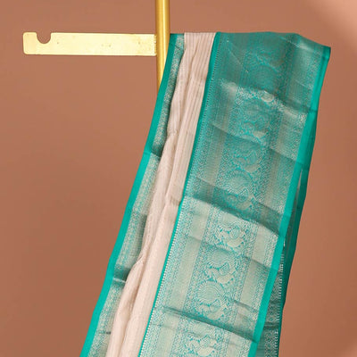Cream striped silk saree with contrast border of thilakam mokku, mayil kann, mayil design & intricate zari design pallu