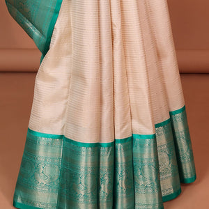 Cream striped silk saree with contrast border of thilakam mokku, mayil kann, mayil design & intricate zari design pallu