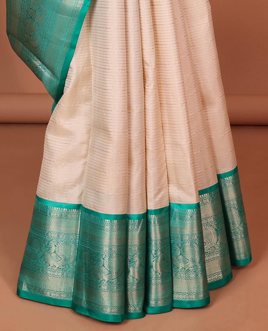 Cream striped silk saree with contrast border of thilakam mokku, mayil kann, mayil design & intricate zari design pallu