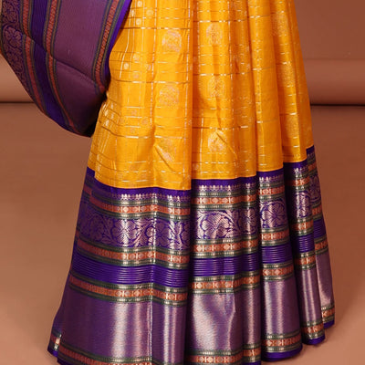 Yellow buttas enclosed with checked silk saree with contrast border of muthu,paun,banaras deisgn & intricate zari pallu