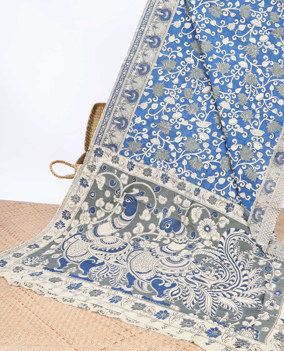 Blue floral machine-printed kalamkari cotton saree, contrast tree motifs border & peacock pallu