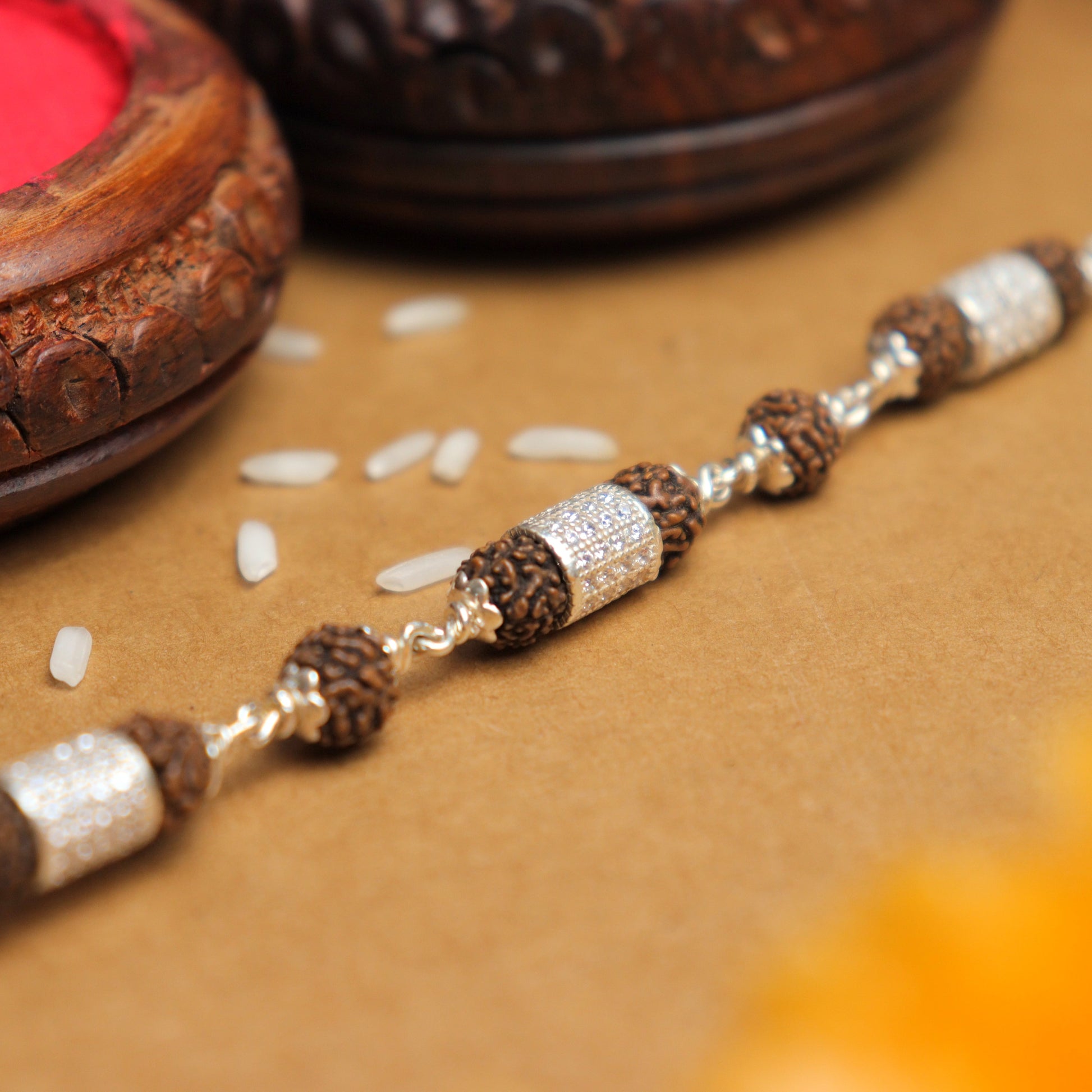 Silver Rakhi with Rudraksha and Three Diamond Cylinders