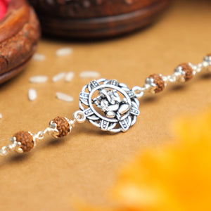 Silver Rakhi with Ganesh in a Designer Circular Sphere and Single Line Rudraksha