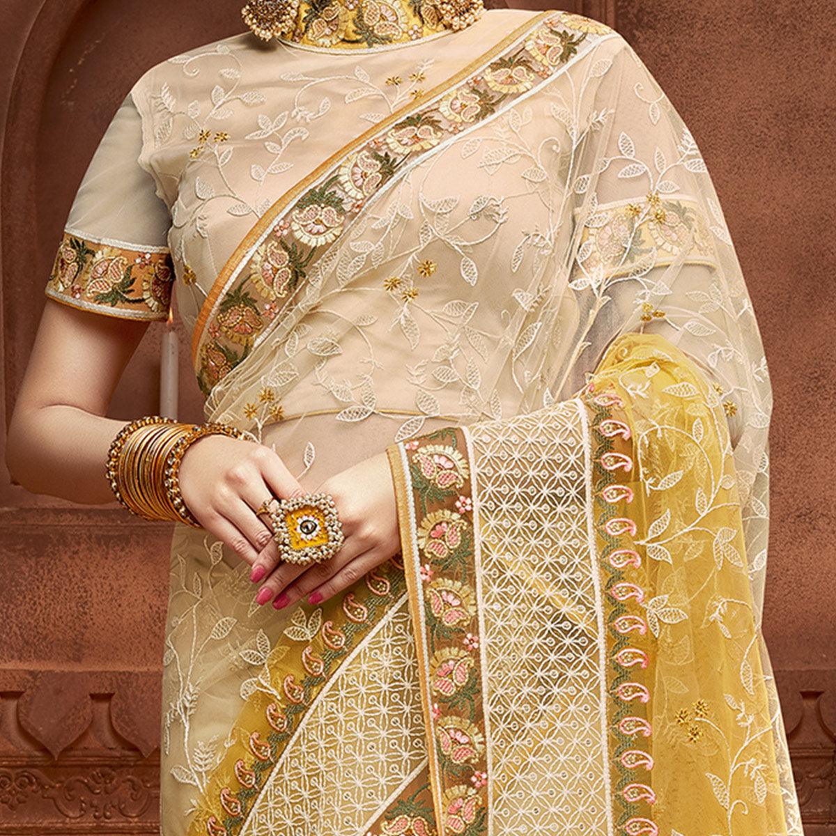 Capricious Beige & Mustard Coloured Partywear Embroidered Soft Net Saree