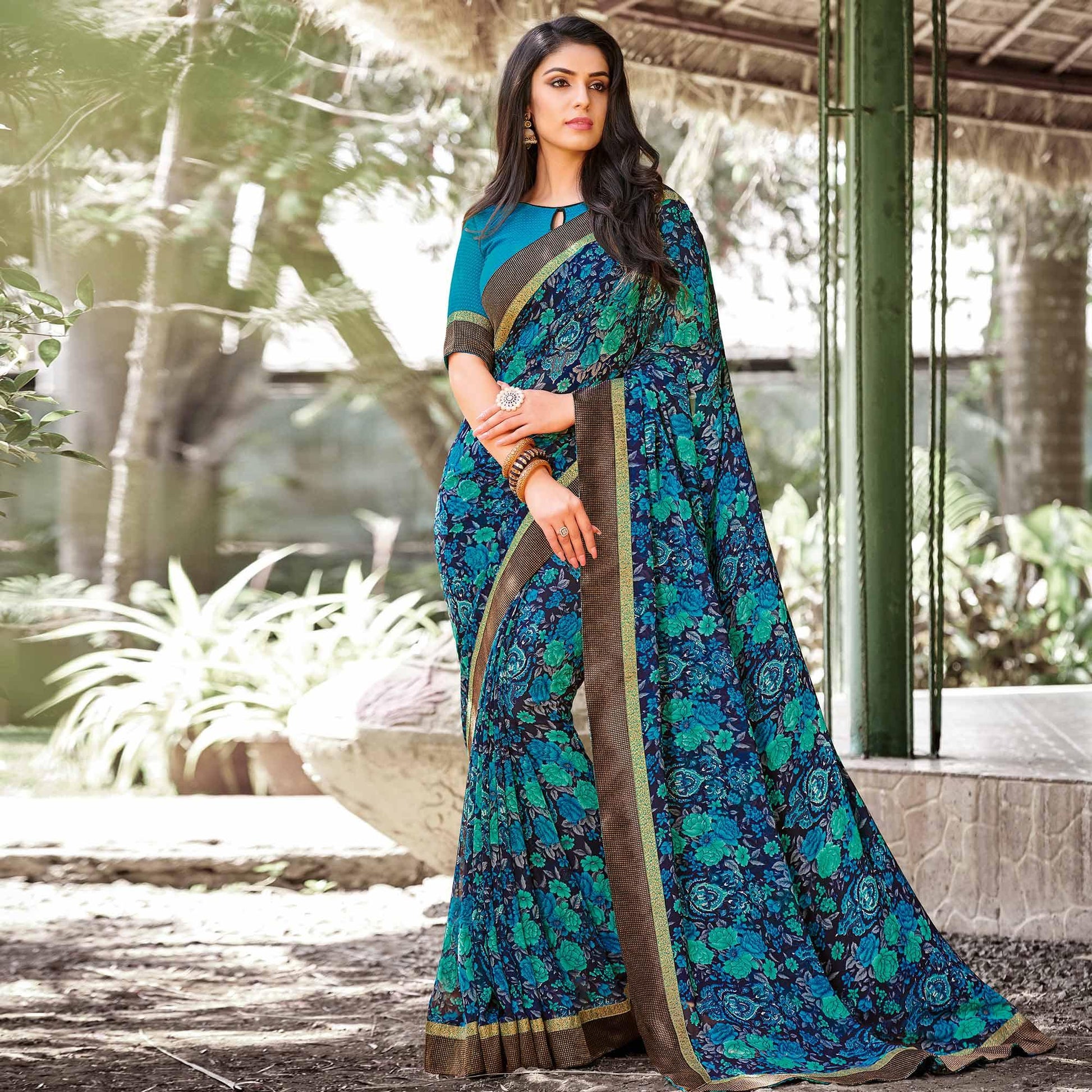 Elegant Peacock Blue Colored Partywear Printed Georgette Saree