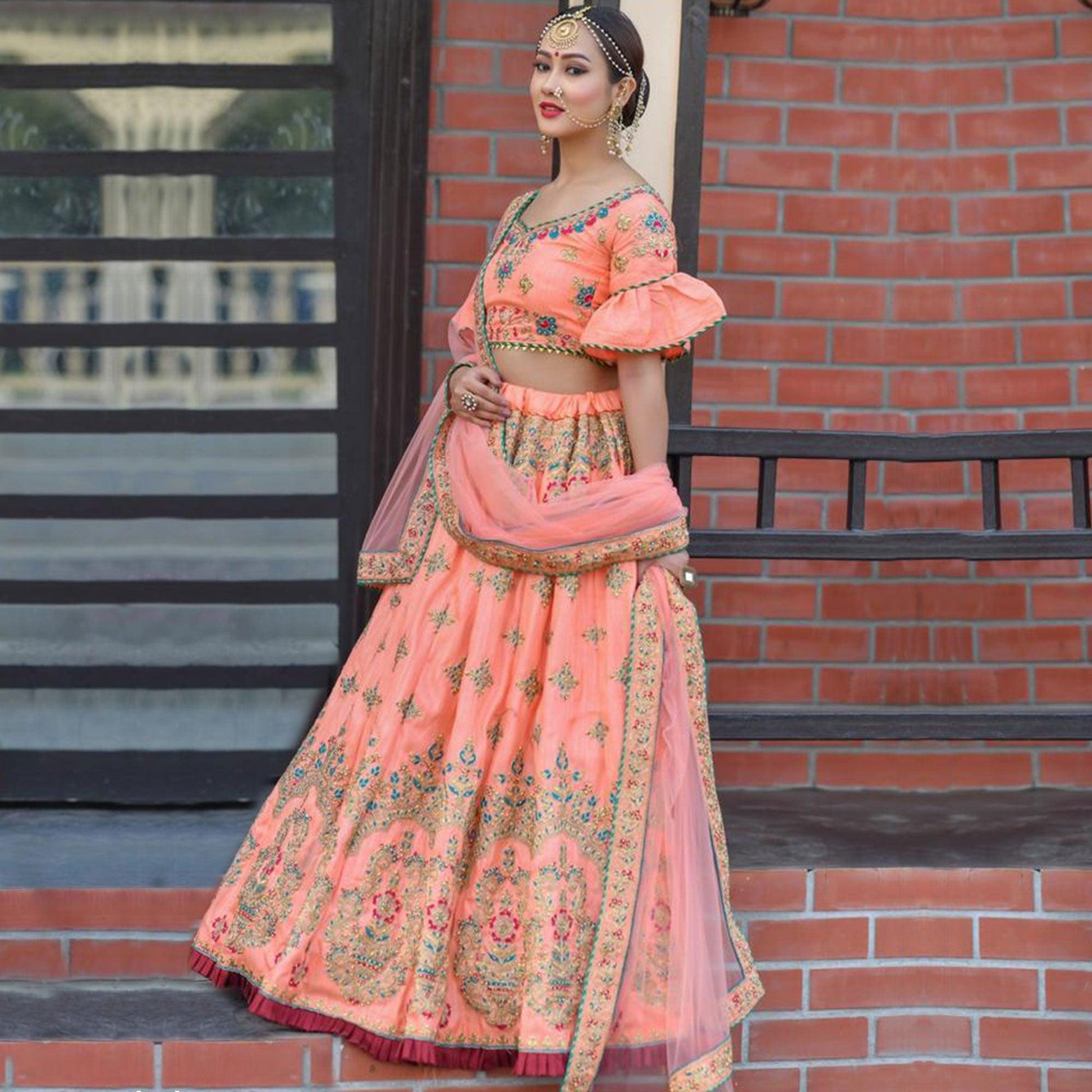 Hypnotic Peach Colored Party Wear Embroidered Silk Lehenga Choli