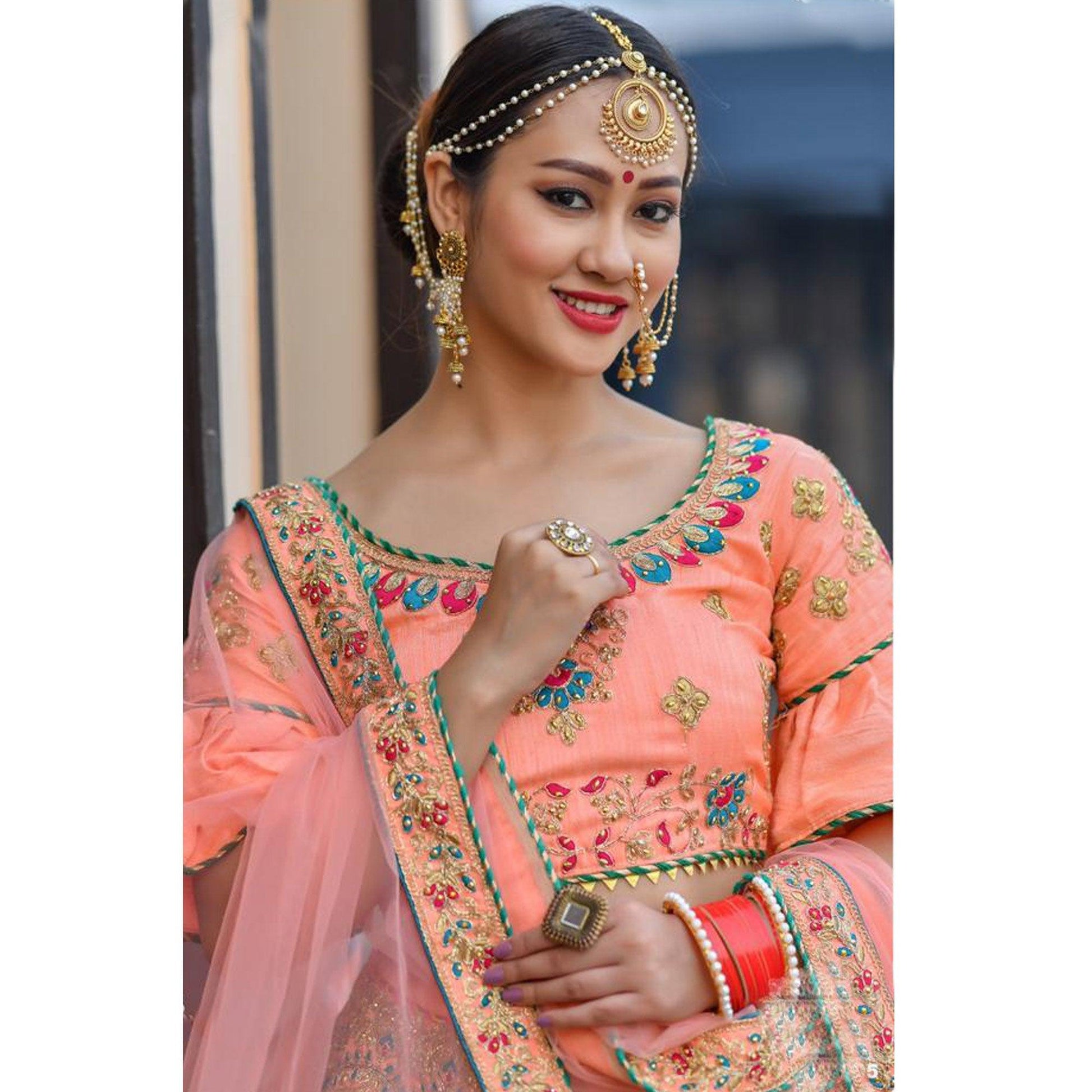 Hypnotic Peach Colored Party Wear Embroidered Silk Lehenga Choli