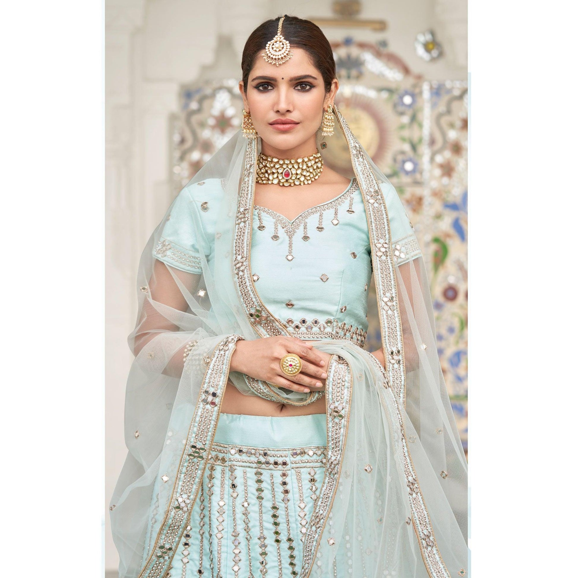 Intricate Ice Blue Coloured Wedding Wear Mirror Work Heavy Silk Lehenga Choli