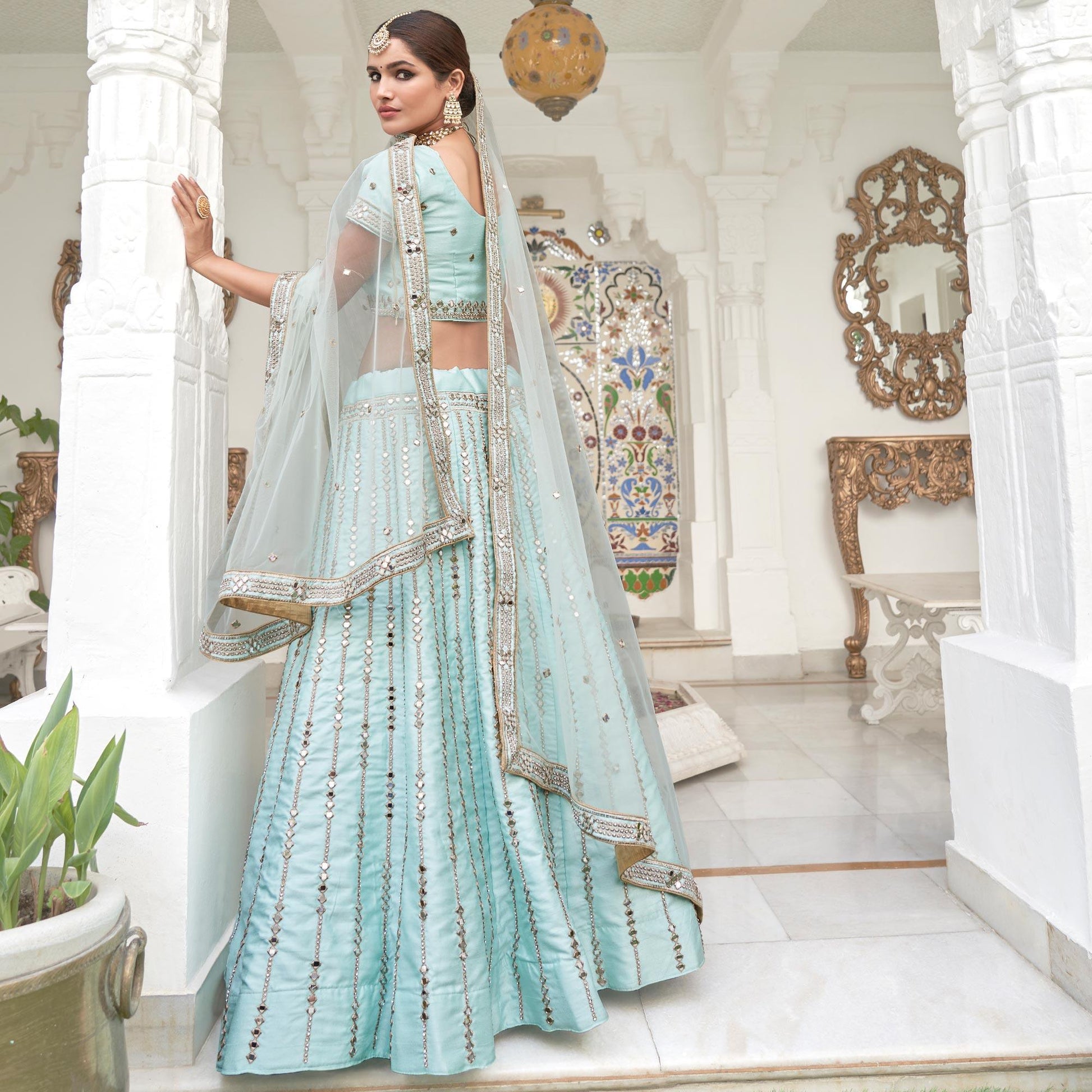 Intricate Ice Blue Coloured Wedding Wear Mirror Work Heavy Silk Lehenga Choli