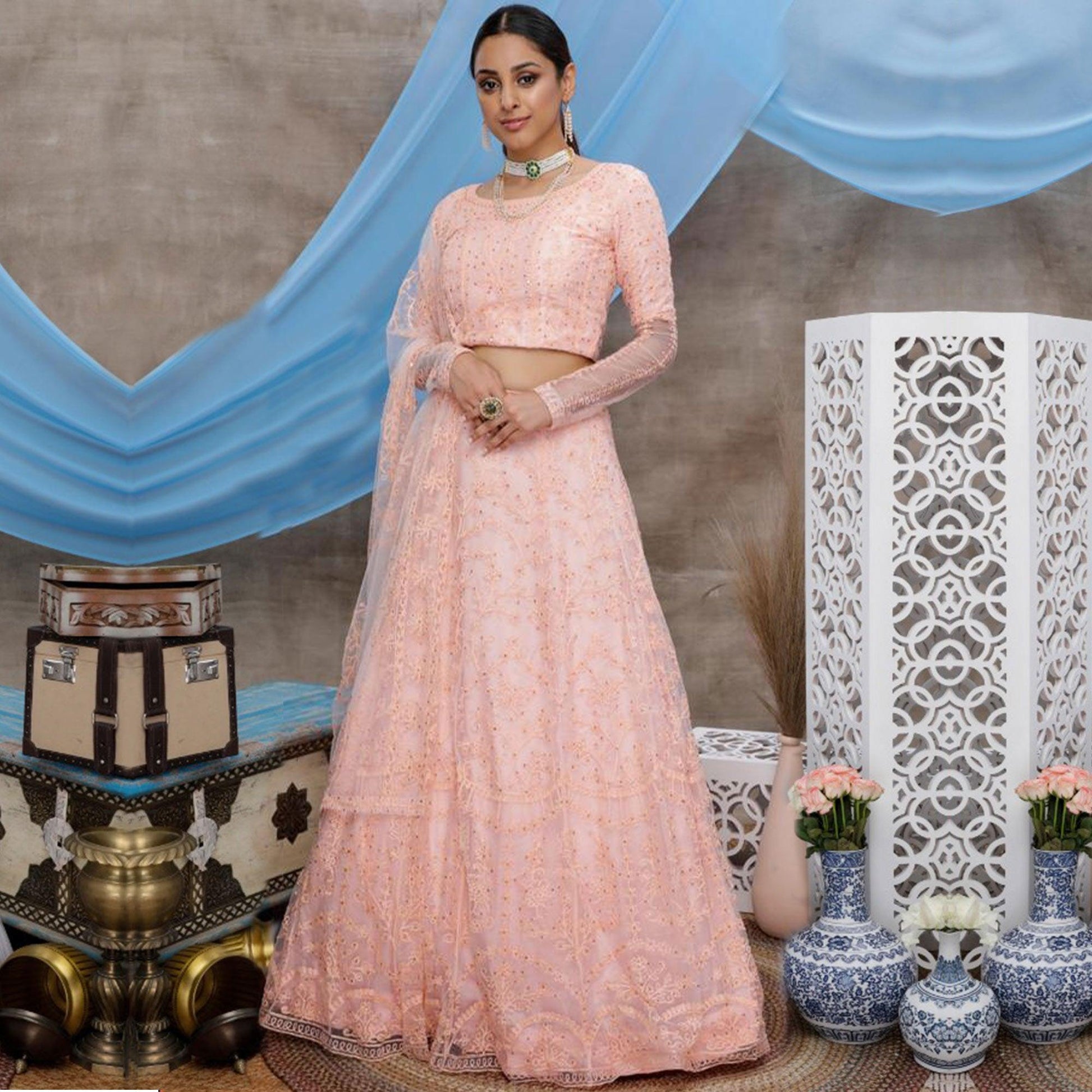 Intricate Peach Colored Party Wear Embroidered Net Lehenga Choli