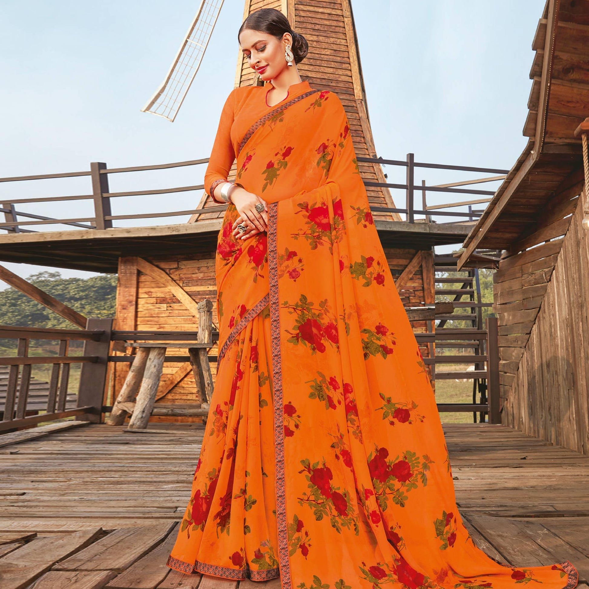 Lovely Orange Coloured Partywear Pure Georgette Floral Printed Saree With Fancy Lace Border